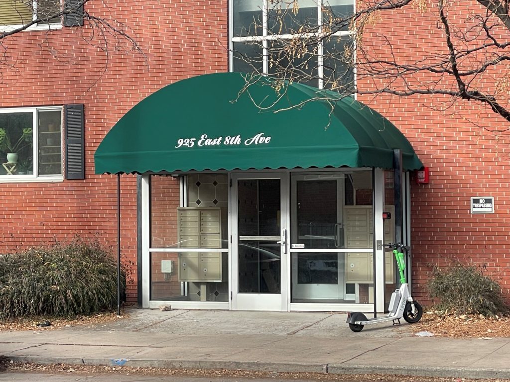 Marquee awning in green for building entrance installed by the pros at A Creative Canvas.